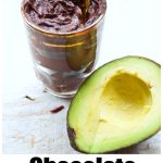 a glass jar with chocolate avocado mousse and half an avocado on the side