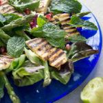 grilled halloumi on a bed of salad with pomegranate seeds