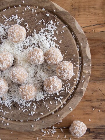 coconut tahini bliss balls on a wooden board