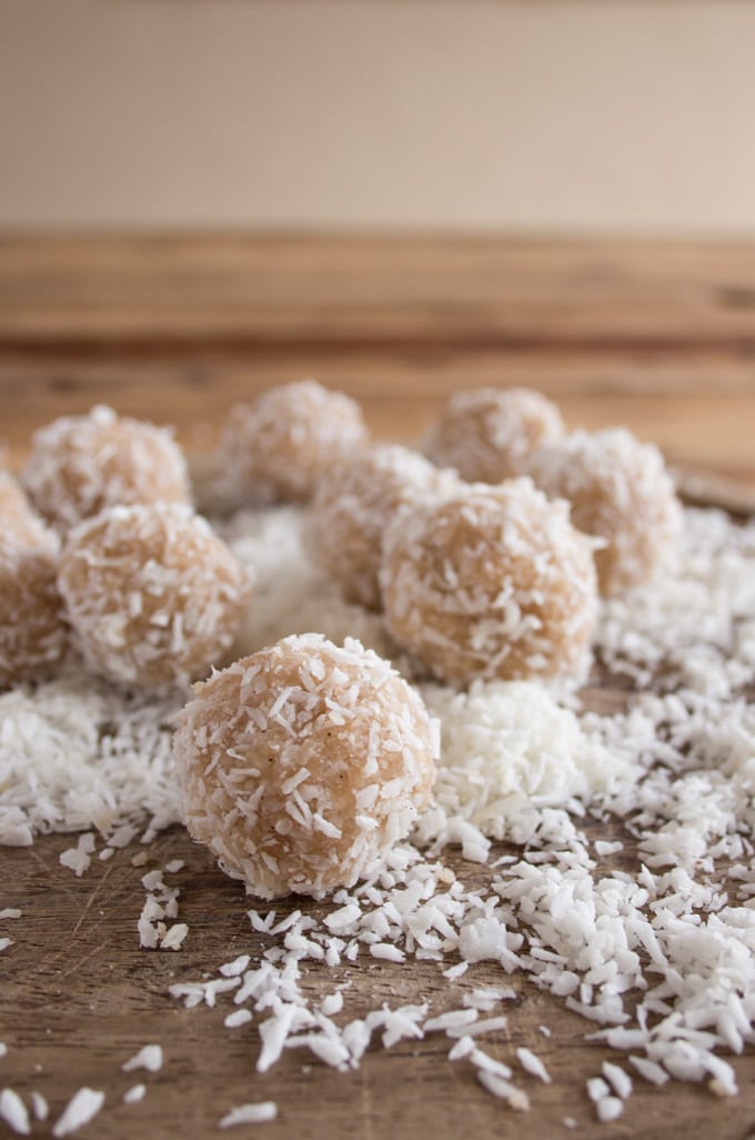 closeup of coconut tahini balls on a wooden board