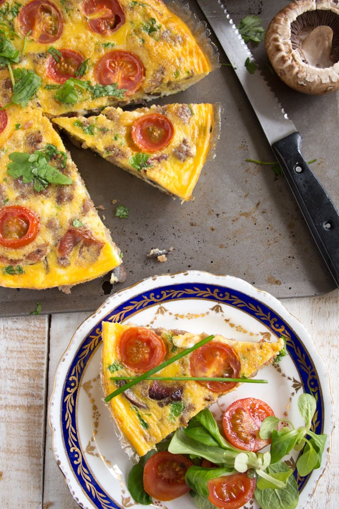 An English breakfast frittata with a knife and a plate on the side