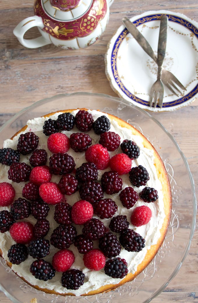 An almond flour cake with a stack of plates and forks 