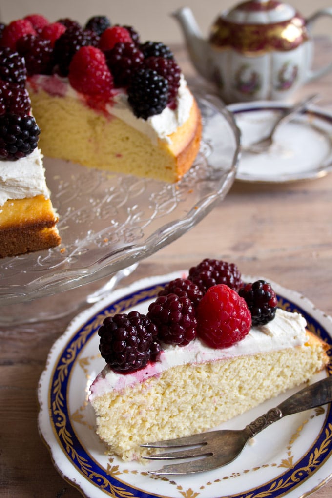 A slice of almond flour cake with mascarpone frosting and berries