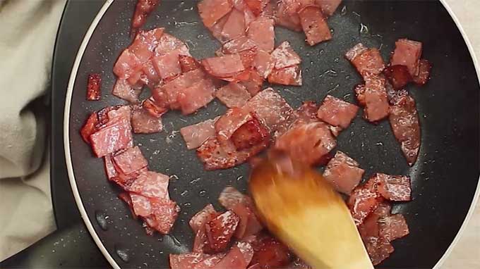 Browning salami in a frying pan
