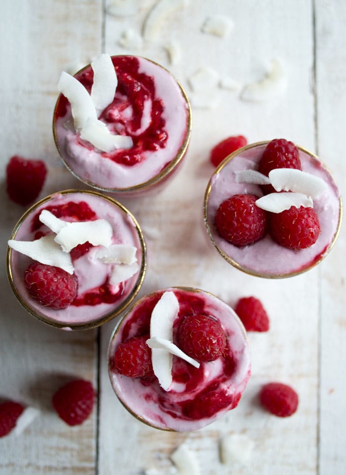 four dessert glasses with raspberry coconut fool