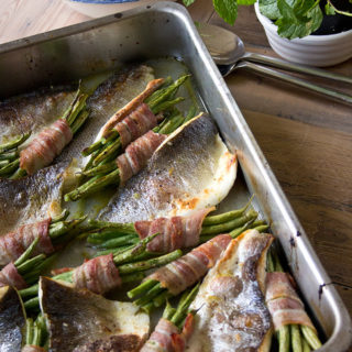 Roast sea bass traybake with bacon-wrapped beans and a salad