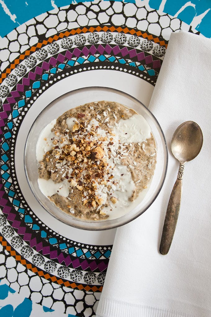 a glass bowl with coffee chia pudding on a tray with a spoon