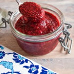 raspberry jam in a jar with a spoon
