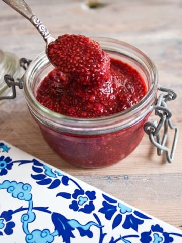 raspberry chia jam in a glass jar with a spoon