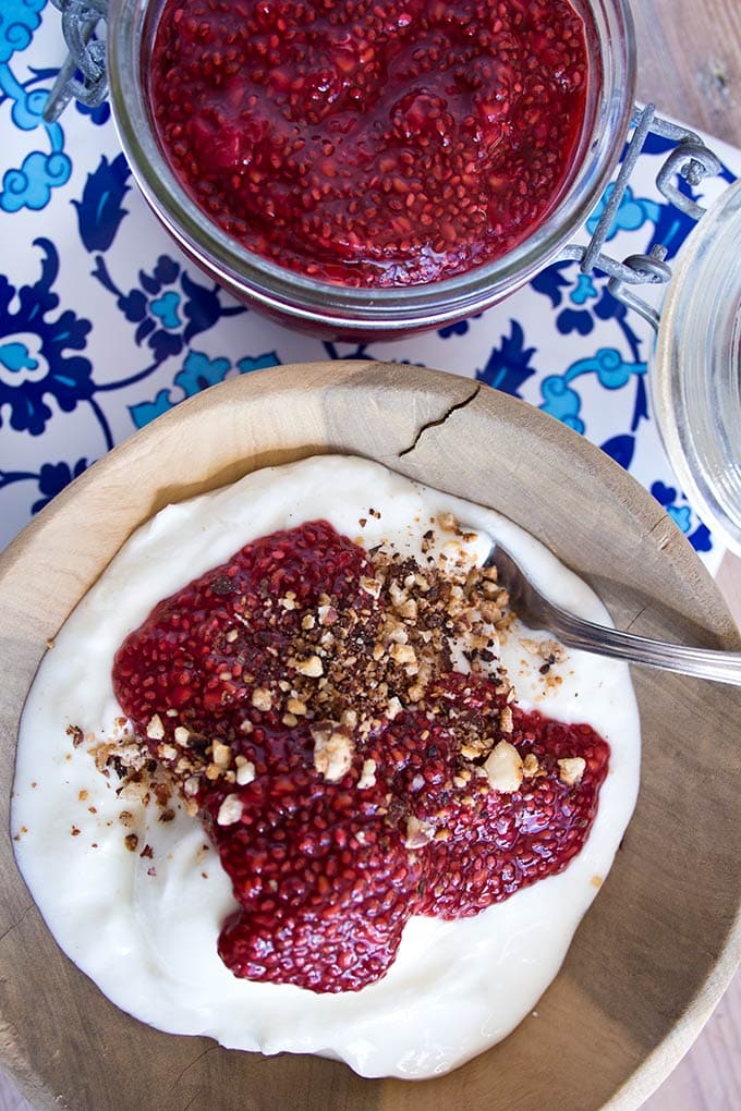 yoghurt with sugar free jam in a wooden bowl with a spoon