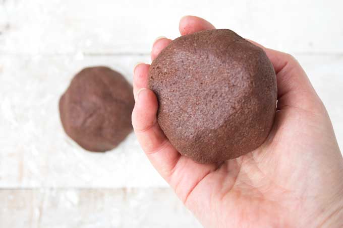 Hand holding a ball of cookie dough