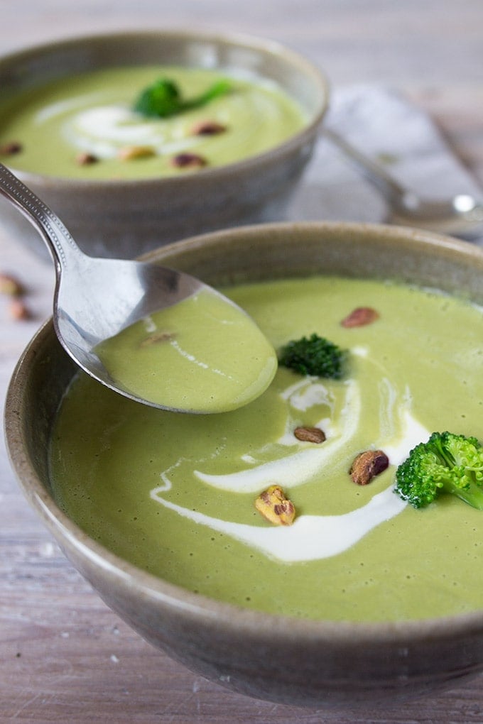 taking a spoonful of broccoli pistachio soup