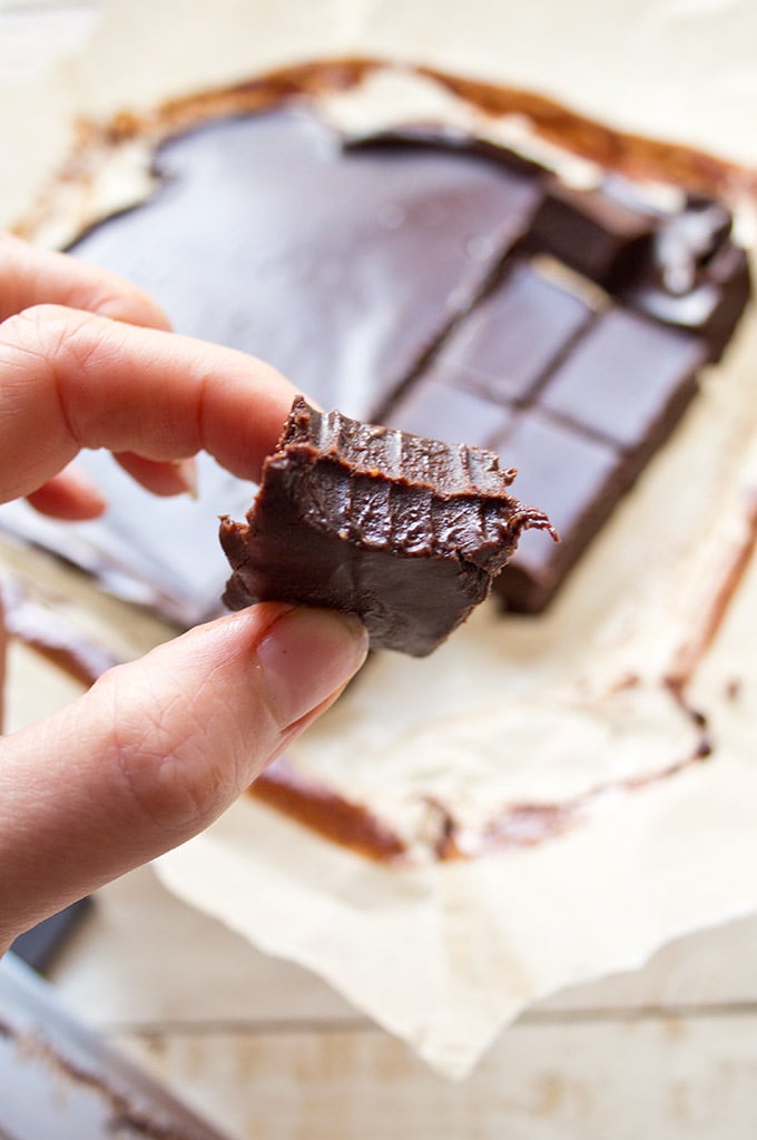 a hand holding a piece of sugar free chocolate peanut butter fudge 