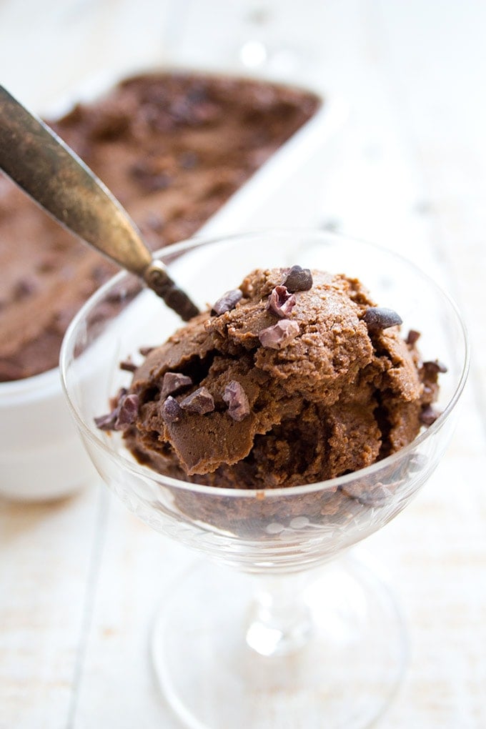 a glass bowl with chocolate avocado ice cram and a spoon