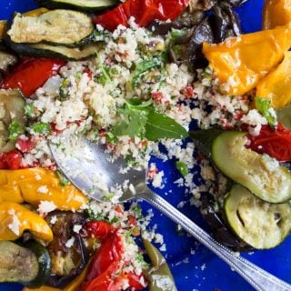 a plate with Moroccan spiced cauliflower rice with roasted vegetables and a spoon