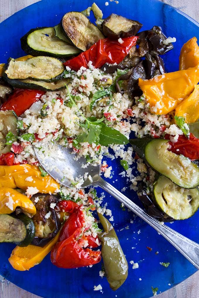 a plate with Moroccan spiced cauliflower rice with roasted vegetables and a spoon