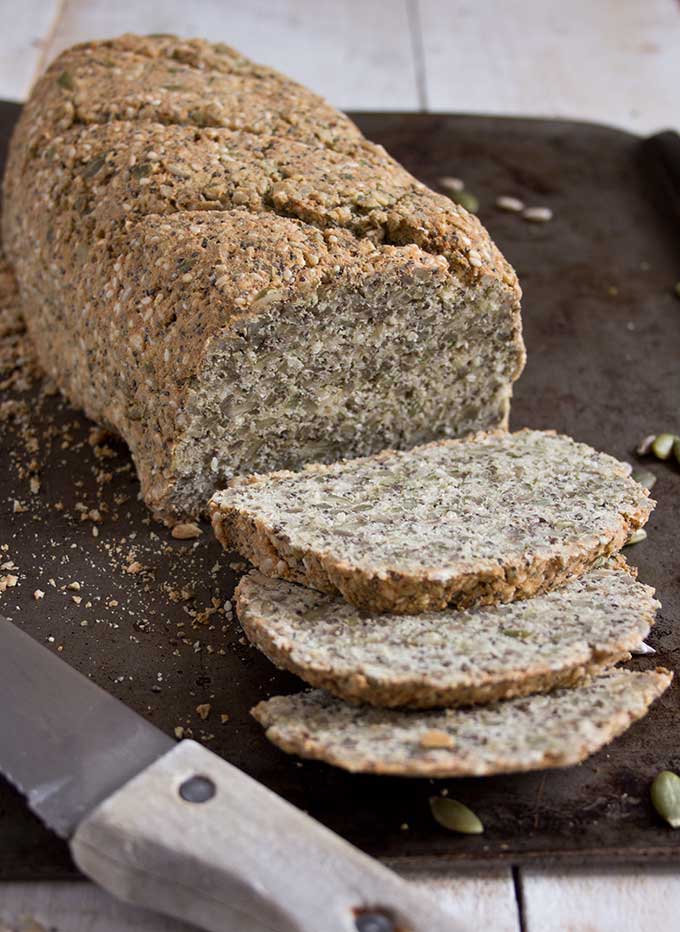 a loaf of paleo bread with slices and a knife