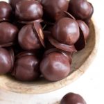 a wooden bowl filled with Keto truffles made with almond butter and coated in chocolate