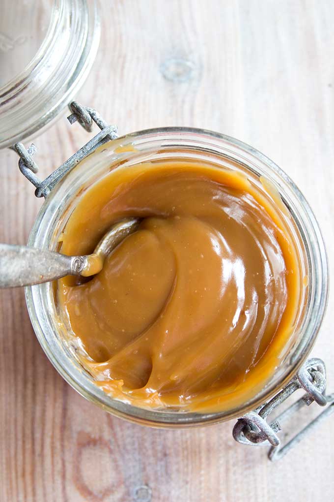 aerial view of a glass jar of sugar free caramel sauce with spoon