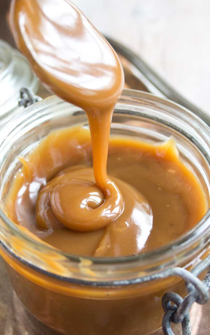 a spoon dripping with sugar free caramel sauce