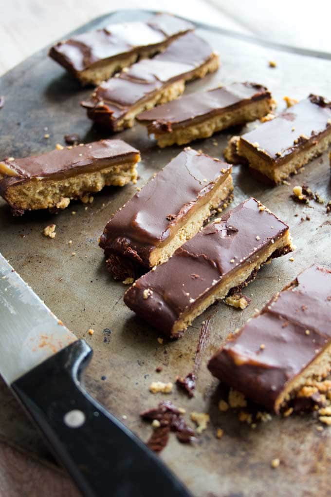 Homemade Twix Bars on a baking sheet and a knife