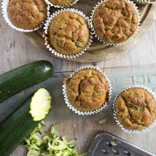 low carb zucchini muffins in paper casings and zucchini being shredded