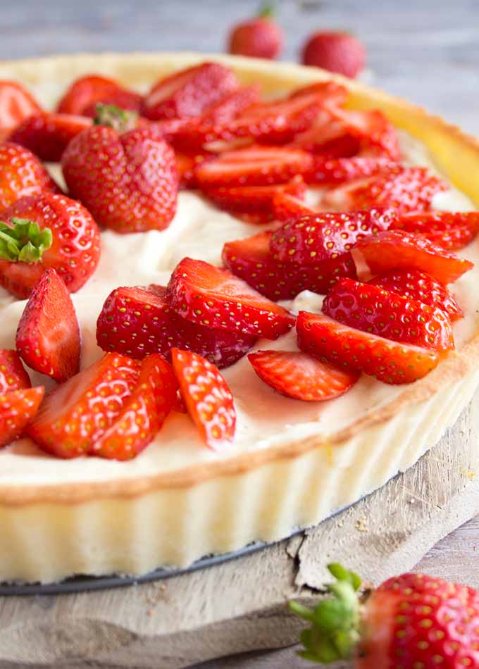 a closeup of a strawberry mascarpone tart decorated with sliced strawberries