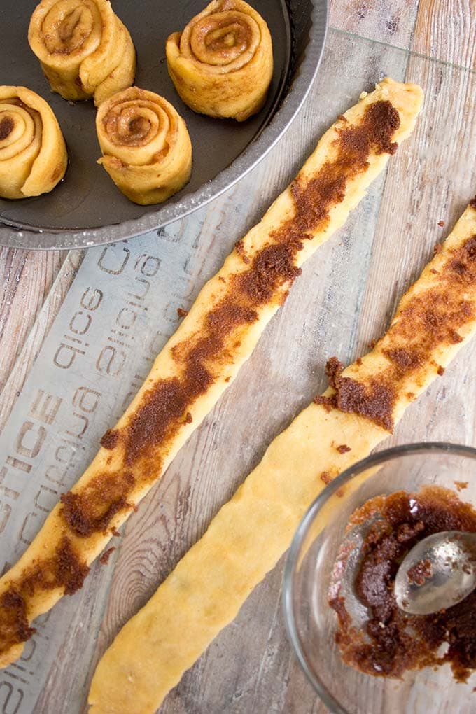 Longues bandes de pâte à rouleau de cinnamon céto avec une garniture à la cannelle et des rouleaux de cannelle non cuits