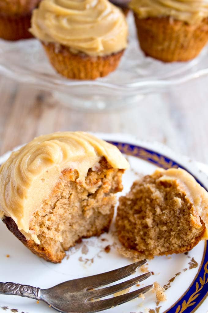 A gingerbread cupcake broken into 2 pieces with a fork in the foreground.