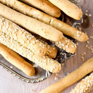 closeup of low carb cheese straws with sesame seeds on a silver tray