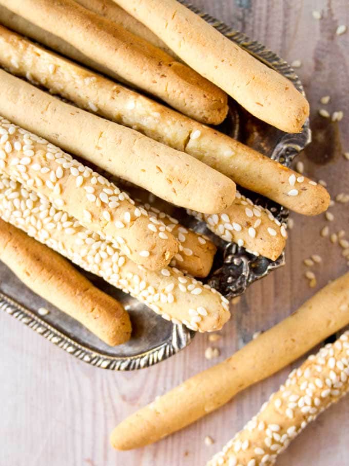 closeup of low carb cheese straws with sesame seeds on a silver tray