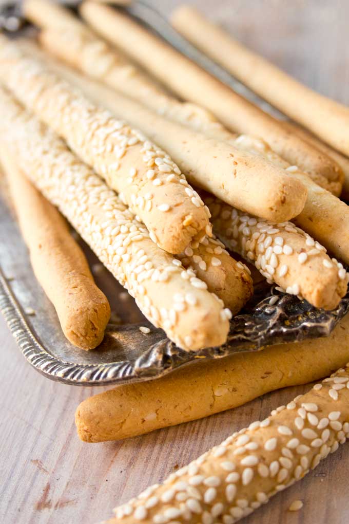 closeup of low carb cheese straws with sesame seeds on a silver tray