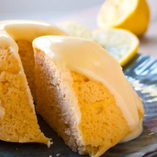 a slice of lemon mug cake on a plate with lemon glaze