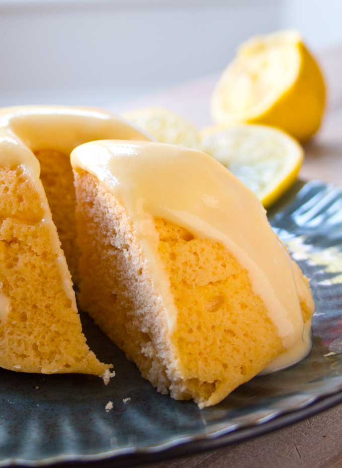 a slice of lemon mug cake on a plate with lemon glaze