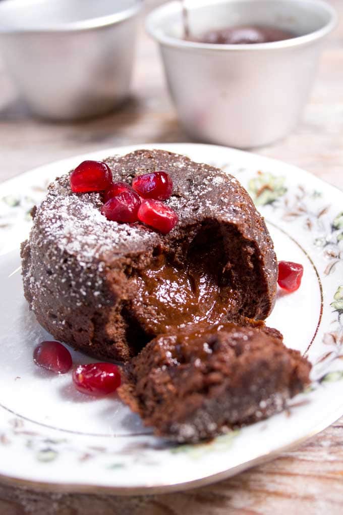 A low carb chocolate lava cake with a gooey molten centre decorated with pomegranate seeds