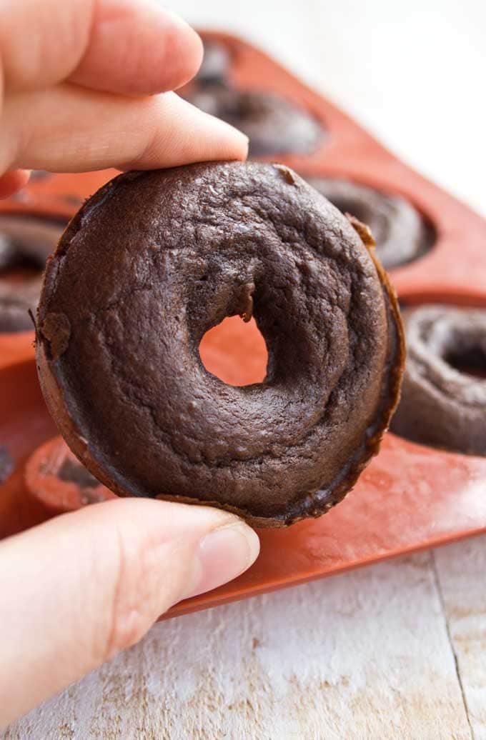 closeup of a Keto chocolate donut held by a hand