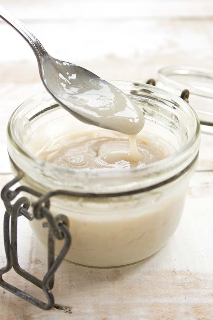 A jar of sugar free condensed milk with a spoon