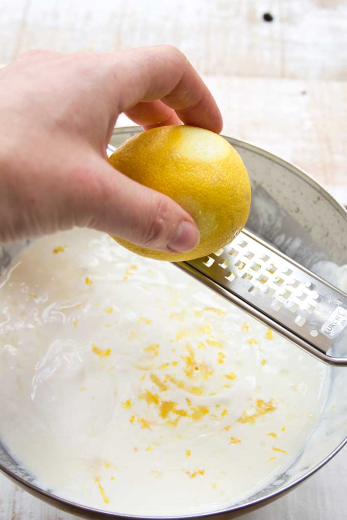 Grating lemon zest into a cheesecake mix