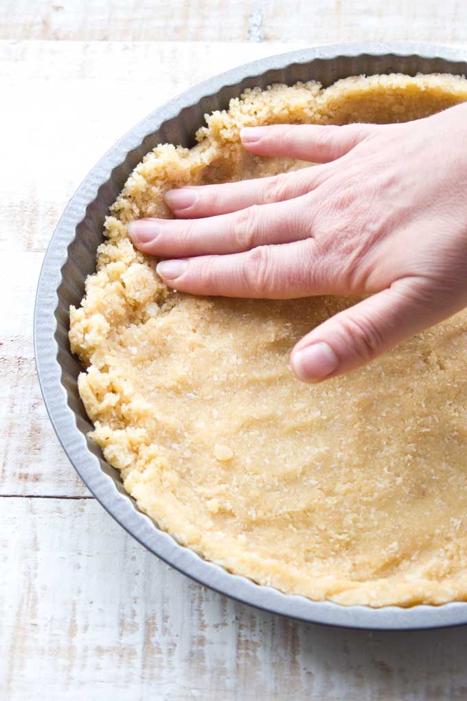 Hand pressing dough into a pie pan