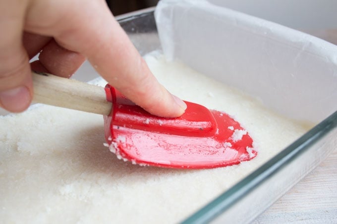 Hand with spatula smoothing coconut mix
