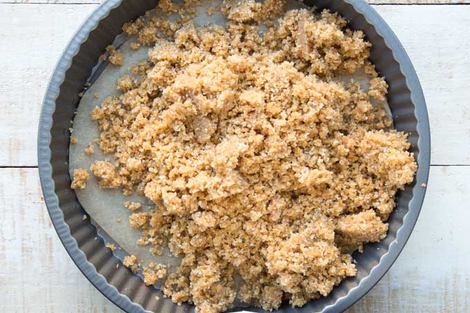 crumbly pie crust mix poured in a pie dish