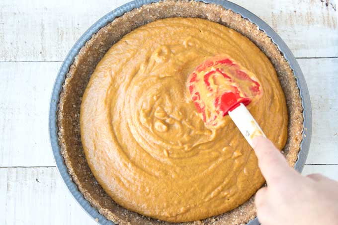 spreading the low carb pumpkin pie filling with a spatula