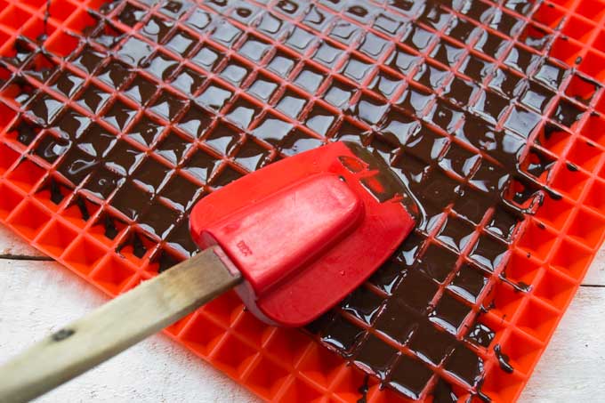 Spreading sugar free chocolate into the silicone mat with a spatula