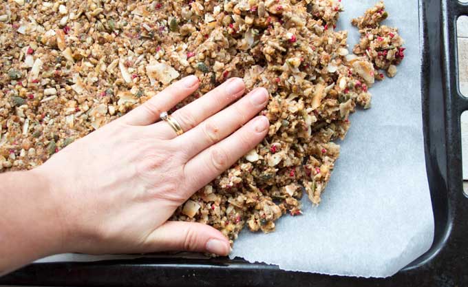 pressing the low carb granola mix onto a baking sheet