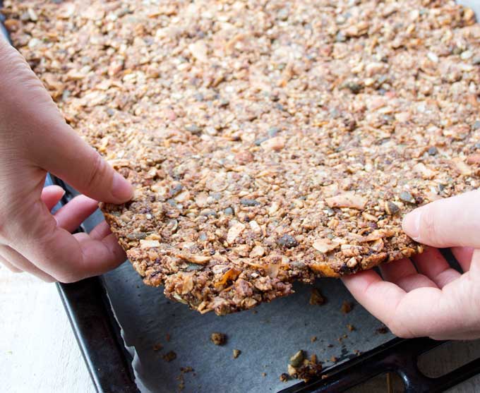 lifting baked low carb granola off the baking tray