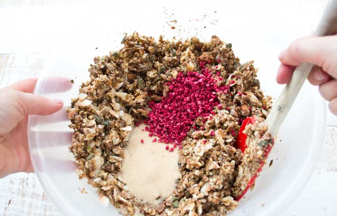 adding granulated sweetener and freeze dried raspberries to low carb granola mix