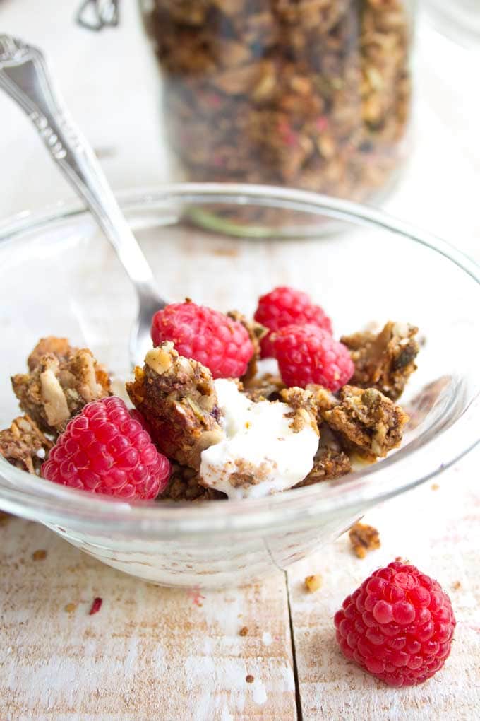 a bowl with low carb granola, yoghurt and raspberries