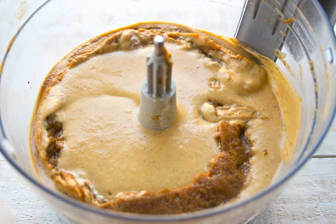 Pumpkin and cream mixture in a food processor bowl.