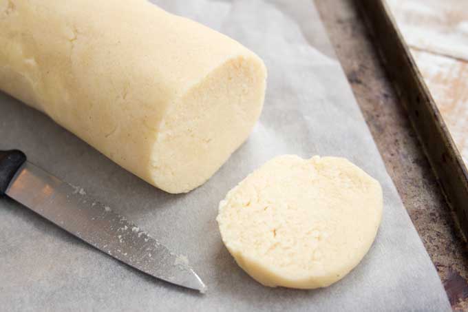 a log of keto sugar cookies dough and a knife