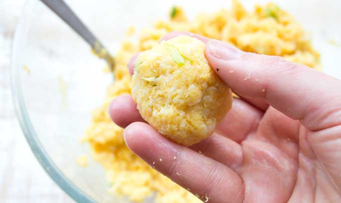 hand holding a cauliflower hash brown dough ball